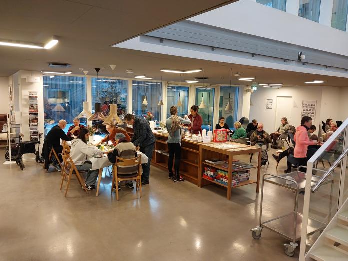 Caféen i Center for Kræft og Sundhed. Der er flere mennesker, der sidder ved borde og drikker gløgg og spiser æbleskiver.